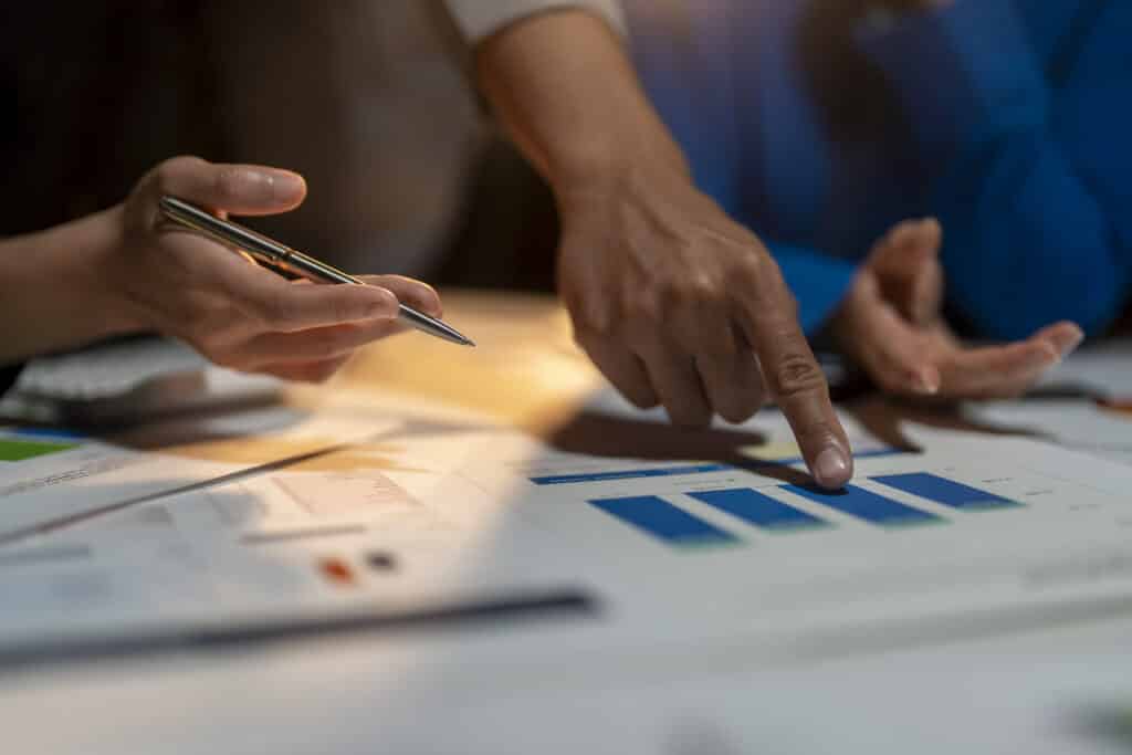 Hands analyzing survey charts beside product samples